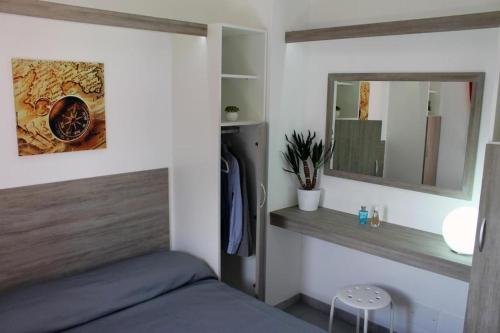 下麦克加诺The Camp by Maggiore Suites的一间卧室配有一张床和镜子