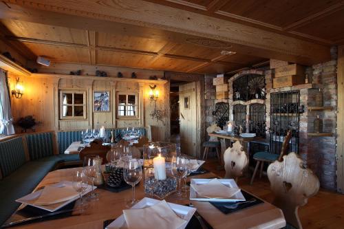 谷雪维尔Hôtel 3 étoiles -Restaurant Le Pilatus Courchevel的用餐室配有带玻璃杯和蜡烛的桌子
