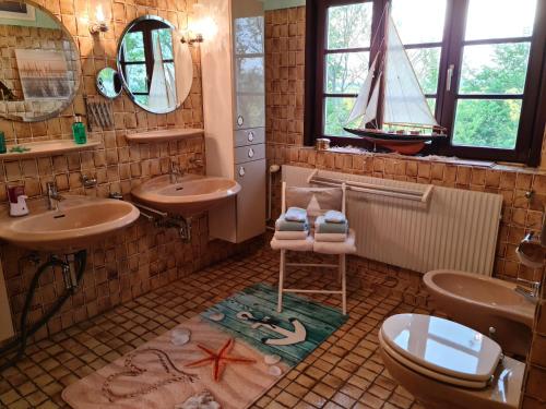 纽克尔逊Ferienwohnung op de Warft的浴室设有2个水槽,地面上设有一艘海盗船。