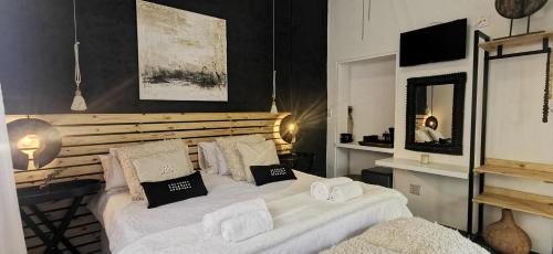 温特和克EXQUISITE PRIVATE LUXURY SUITE WITH KING BED at BOKMAKIERIE VILLAS的一间卧室配有两张带毛巾的床