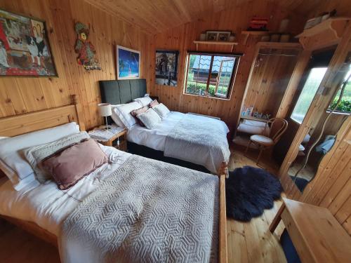 基尔肯尼Cosy Countryside Log Cabin的小木屋内一间卧室,配有两张床