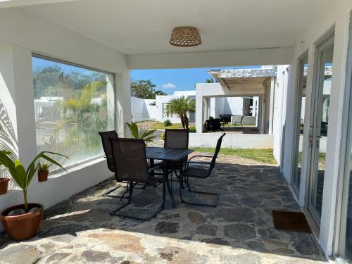 CocléModerna casa con piscina a 10 min de la playa的门廊上配有桌椅的天井