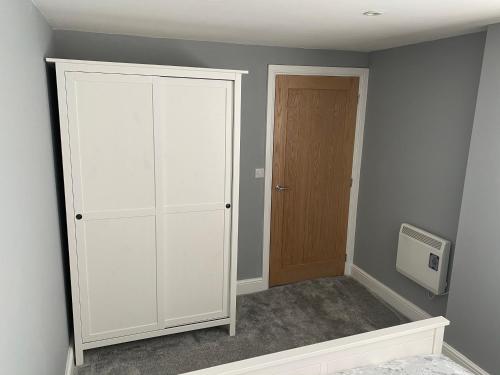 High HeatonNewly Refurbished Entire Apartment - South Gosforth, Newcastle的一间设有白色橱柜和门的房间