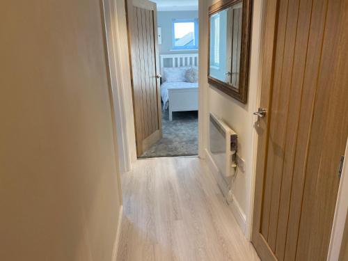 High HeatonNewly Refurbished Entire Apartment - South Gosforth, Newcastle的走廊通往带镜子的卧室
