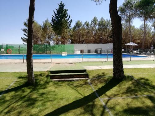 El Bonillocasas rurales la lagunilla的前方有两棵树的网球场