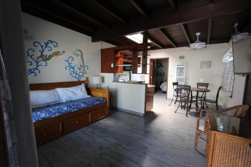 圣克鲁兹厄齐沃特海滩套房酒店的一间卧室配有一张床、一间厨房和一个用餐室