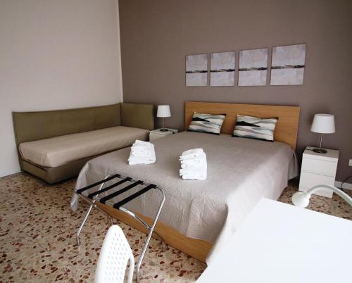 卡塔尼亚Giuffrida Apartment Rooms的一间带两张床和一张沙发的卧室