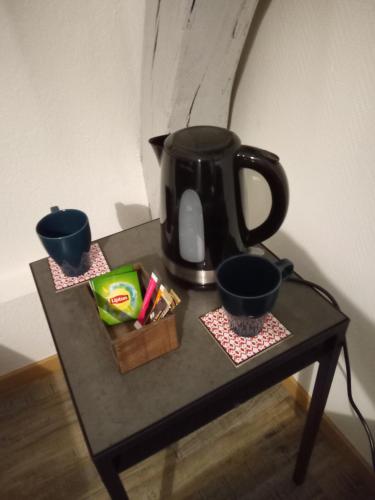 ChoiseyLE MARCEL appartement F1 de 24 m²的一张桌子上装着两杯黑咖啡壶