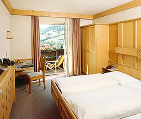 涅德劳奥地利酒店的一间带一张床和一张书桌的卧室以及一个阳台