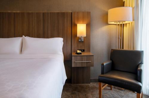 纳什维尔Holiday Inn Nashville Vanderbilt, an IHG Hotel的在酒店房间的床和椅子