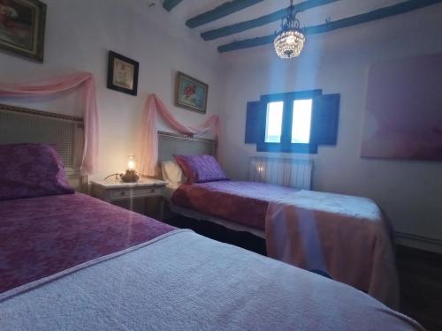 Santa Eulalia BajeraRiojania Heredad的一间卧室配有两张床和吊灯。