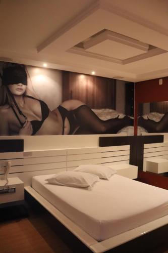 拉热斯Motel Chevalier的卧室配有一张带女性绘画的床