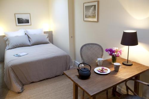 勒帕莱Les Appartements d'Alexandre的一间卧室配有一张床和一张带果盘的桌子