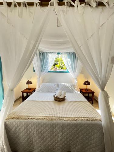 帕拉蒂Villa Tiê Paraty的卧室配有带白色窗帘的床和窗户。