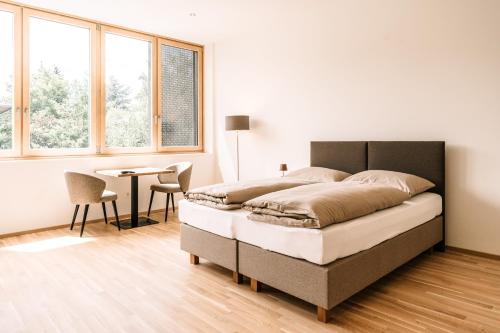 因斯布鲁克LOOMZ living Self-check-in的卧室配有床、桌子和窗户。