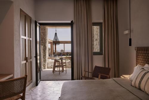 埃利亚海滩Archipelagos All Suites的卧室配有一张床,享有桌子的景色