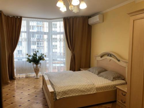 利沃夫VIP Апартаменти Львів Сихів центр Червоної Калини的一间卧室设有一张床和一个大窗户