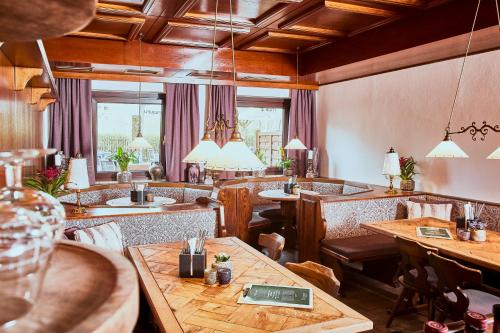 萨尔茨堡优博夫尔精品酒店的餐厅设有木桌、椅子和窗户。
