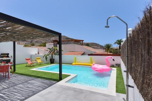 拉普拉亚蒂陶洛Tauro Serenity by VillaGranCanaria的后院的游泳池,带有粉红色的火烈鸟