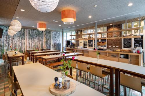 索斯特Stayokay Hostel Soest的一间带桌椅的餐厅和一间酒吧