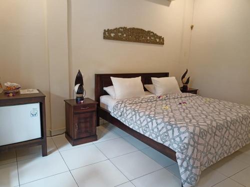 罗威那Rumah Askara的一间卧室配有一张床和电视
