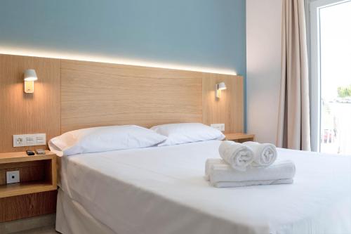 科尼尔-德拉弗龙特拉Rio Salado Conil Hostal的卧室配有带毛巾的大型白色床