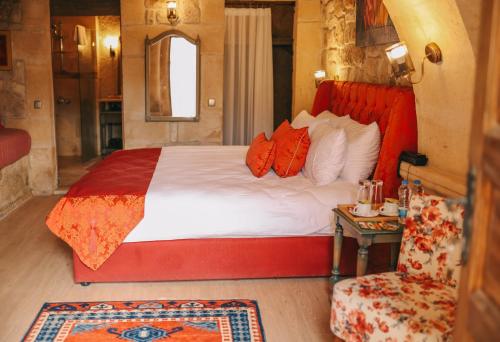 奥塔希萨尔Elaa Cave Hotel的一间卧室配有一张大床和一把椅子