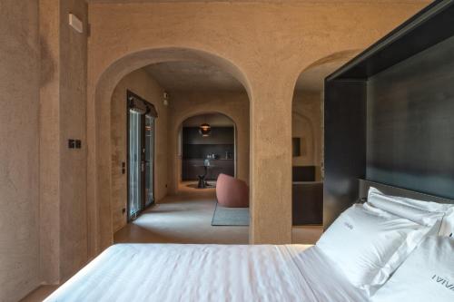 蒙泰穆尔洛I Vivai的一间卧室配有一张床和一张粉红色的椅子