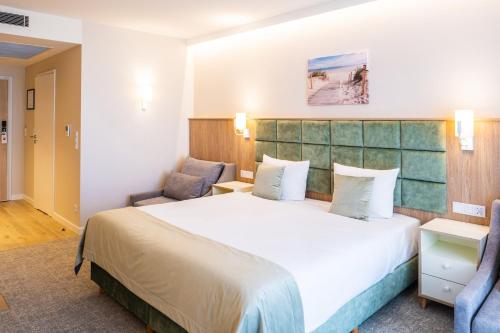 米兹多洛杰Bel Mare Aqua Resort的酒店客房带一张大床和两张椅子
