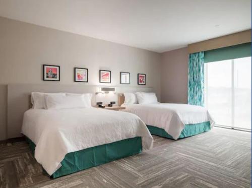 维塞利亚Hilton Garden Inn Visalia, Ca的酒店客房设有两张床和窗户。