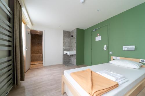 巴黎巴黎阿德维尼亚特旅舍的一间卧室配有一张带绿色墙壁的床