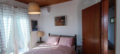 普雷韦扎House in Zaloggo的一间卧室配有带粉红色枕头的床和窗户。