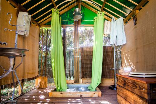 Montes da Estrada费古艾琳哈厄科图里斯默乡村民宿的室外淋浴,室内配有绿色窗帘