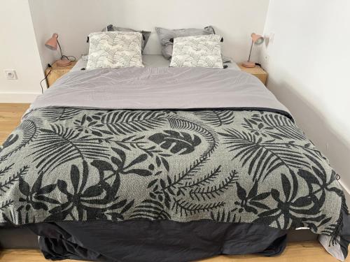 巴约讷Studio centre Bayonne的一张带黑白毯子和枕头的床