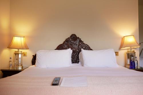 索尔兹伯里彭布罗克阿姆斯酒店的一间卧室配有一张大床和两盏灯