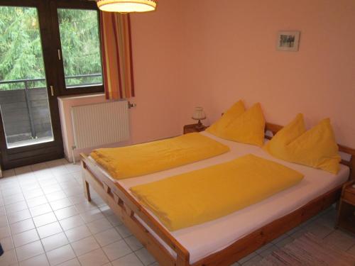 Bromberg斯塔赫尔森林旅馆的卧室内的一张带黄色床单和枕头的床