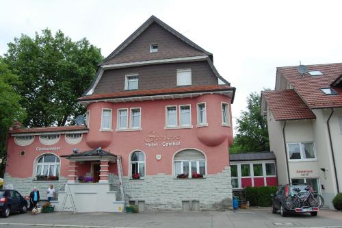 博登斯边的拉多夫采尔Gasthof Seerose的一座大型粉红色建筑,屋顶为棕色