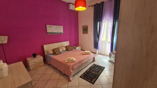 Sogliano CavourCasa Rosa的一间小卧室,配有一张床和紫色的墙壁