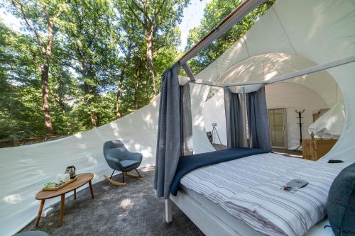 诺茨瓦约Nomád Glamping的帐篷内的卧室,配有一张床和一张书桌