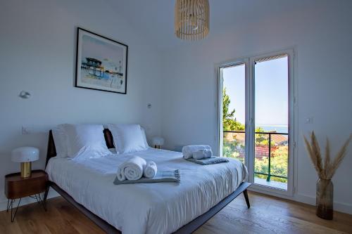 派拉索梅O'DYSSEE Appartement vue panoramique Bassin d'Arcachon的白色卧室,配有带毛巾的床