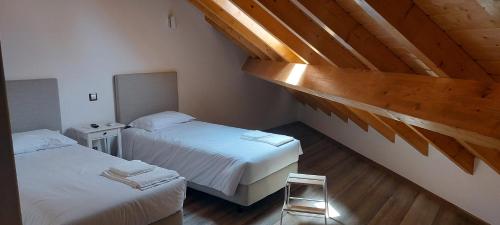 圣地亚哥-杜卡森Alojamento Local - Covas的一间卧室设有两张床和木制天花板