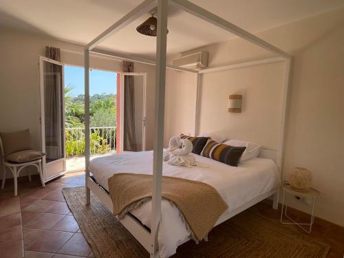 圣马克西姆Fantastic pool villa 900m to the beach; with extravagant big garden的卧室配有白色的天蓬床和阳台