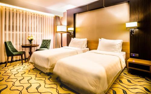 KırklareliLozengrad Hotel的酒店客房设有两张床和一张桌子。