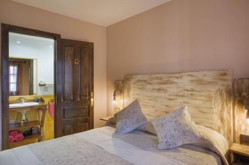 毕斯卡斯El Rincón de Andrea Habitaciones的一间卧室配有一张带木制床头板和水槽的床。