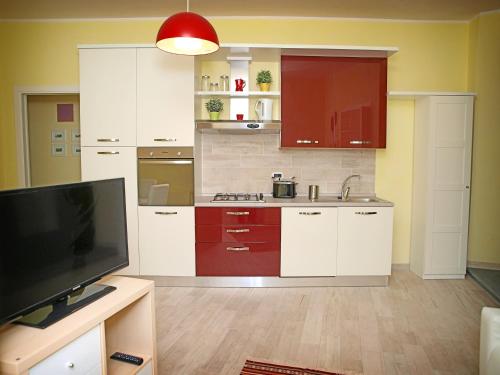奥维多Appartamenti Pistrella的厨房配有白色橱柜和平面电视。