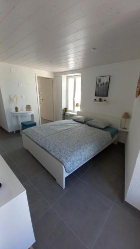Port-ValaisAloha chambres的一间白色客房内配有一张大床的卧室