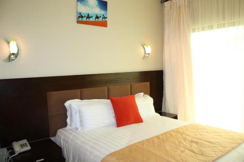 卢萨卡Nomads Court Chudleigh的一间卧室配有一张红色枕头的床