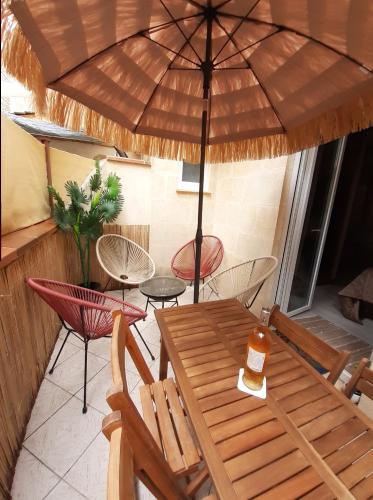 波尔多Bordeaux Chartrons superbe T2 avec terrasse的露台的遮阳伞下的桌椅
