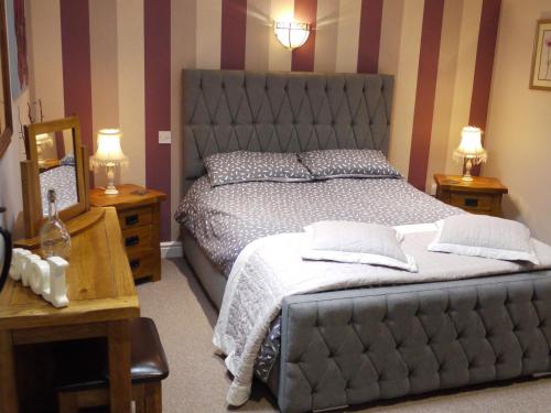 Llanafan-fawrCwm Derw Cottage的一间卧室设有一张大床和两个床头柜