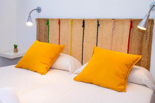 塞博河畔卡莱塔Eslanzarote El Ancla House, wifi, Sea views的床上有两张黄色枕头